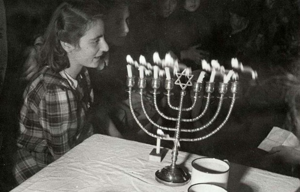 [בתמונה: הדלקת נרות חנוכה במחנה עקורים באוסטריה, 1947. התמונה היא נחלת הכלל]