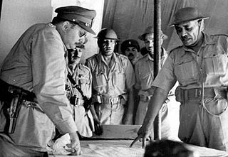 [בתמונה: מפקד חיל המשלוח המצרי גנרל אחמד עלי אל מוואווי (מימין), מקבל את המלך פארוק (משמאל) בביקורו בחזית המצרית בפלשתינה, 7.7.1948. התמונה: סוכנות הידיעות AP]