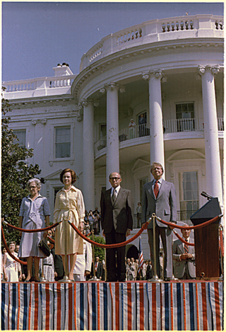 [בתמונה משמאל: פחות מחודש לאחר היבחרו, קבלת פנים חגיגית לראש הממשלה מנחם בגין ורעייתו על ידי הנשיא קרטר ורעייתו בוושינגטון, 19 ביולי 1977]
