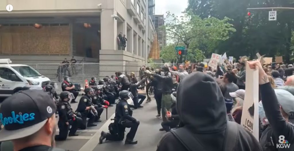 [בתמונה: שוטרים כורעים ברך לאות הזדהות ואמפתיה עם המפגינים. כך מחזירים אמון... התמונה היא צילום מסך]