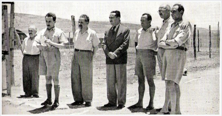 [בתמונה: שבעה ממנהיגי היישוב העצורים במחנה המעצר בלטרון, לאחר השבת השחורה. שם הצלם אינו ידוע. התמונה היא נחלת הכלל]