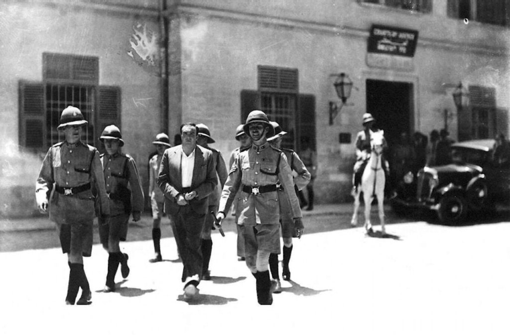 [בתמונה: אברהם סטבסקי, החשוד ברצח ארלוזרוב, מובל למשפטו על ידי המשטרה הבריטית. התמונה הועלתה לויקיפדיה ע"י צבי אורון, ומאושרת לשימוש חופשי]