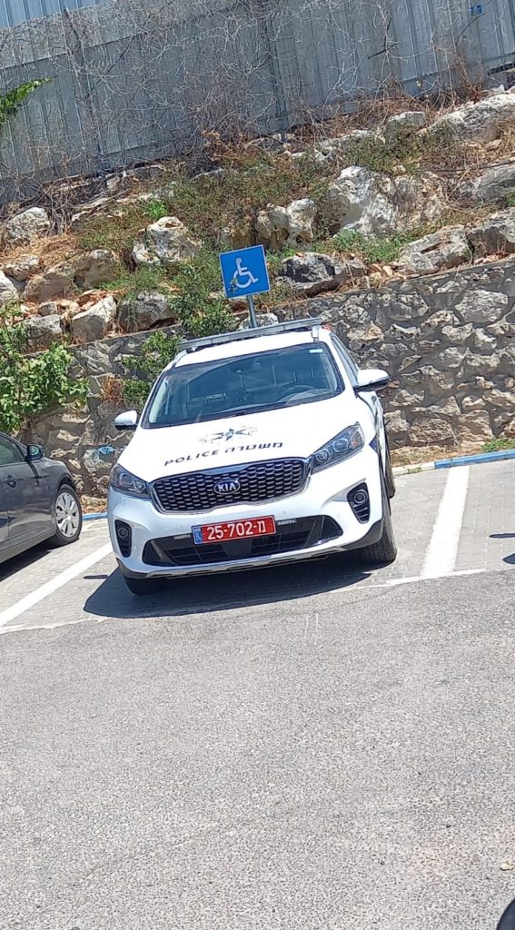 [בתמונה: ניידת חונה בחניית נכים. התמונה שותפה ע"י עו"ד פנחס פישלר בפייסבוק. הצלם אינו ידוע]