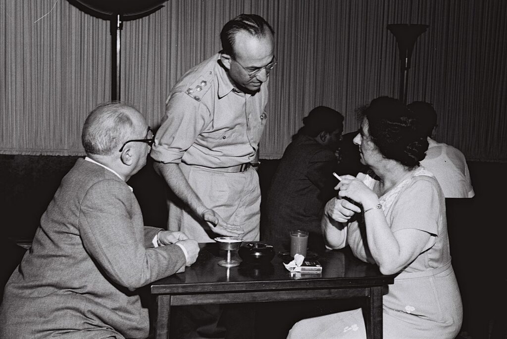 [בתמונה: המפכ"ל הראשון, יחזקאל סהר (עומד) משוחח עם גולדה מאיר ודוד רמז בשנת 1949. הצלם: טדי בראונר, לע"מ, ארכיון התמונות הלאומי]