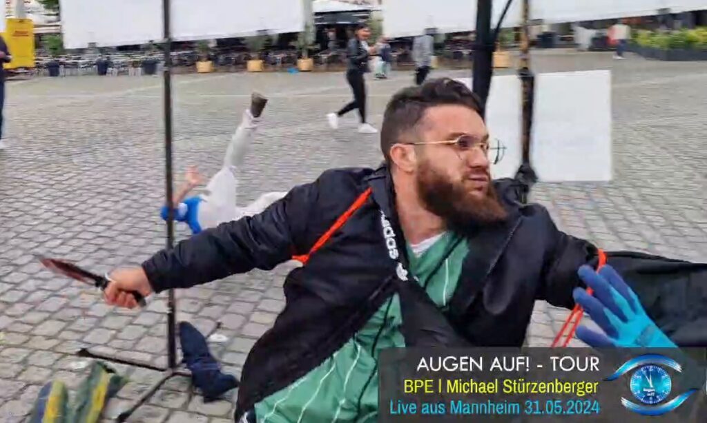 [המפגין האפגאני מתמונת השער, סולימאן עטאיי מהראט, בבדרכו לדקור שוטר גרמני... . צילום: Foto: Augen auf! (YouTube) / © Oliver Zimmer]