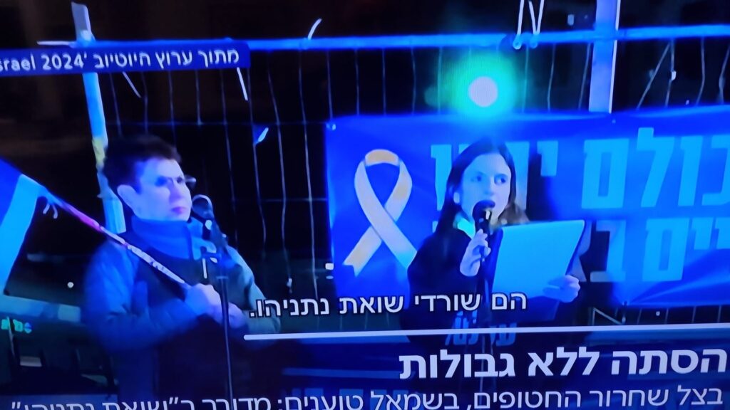 [בתמונה: עו"ד נאוה רוזוליו מתייגת במהלך המחאה את החטופים כ'שורדי שואת נתניהו"... התמונה היא צילום מסך]